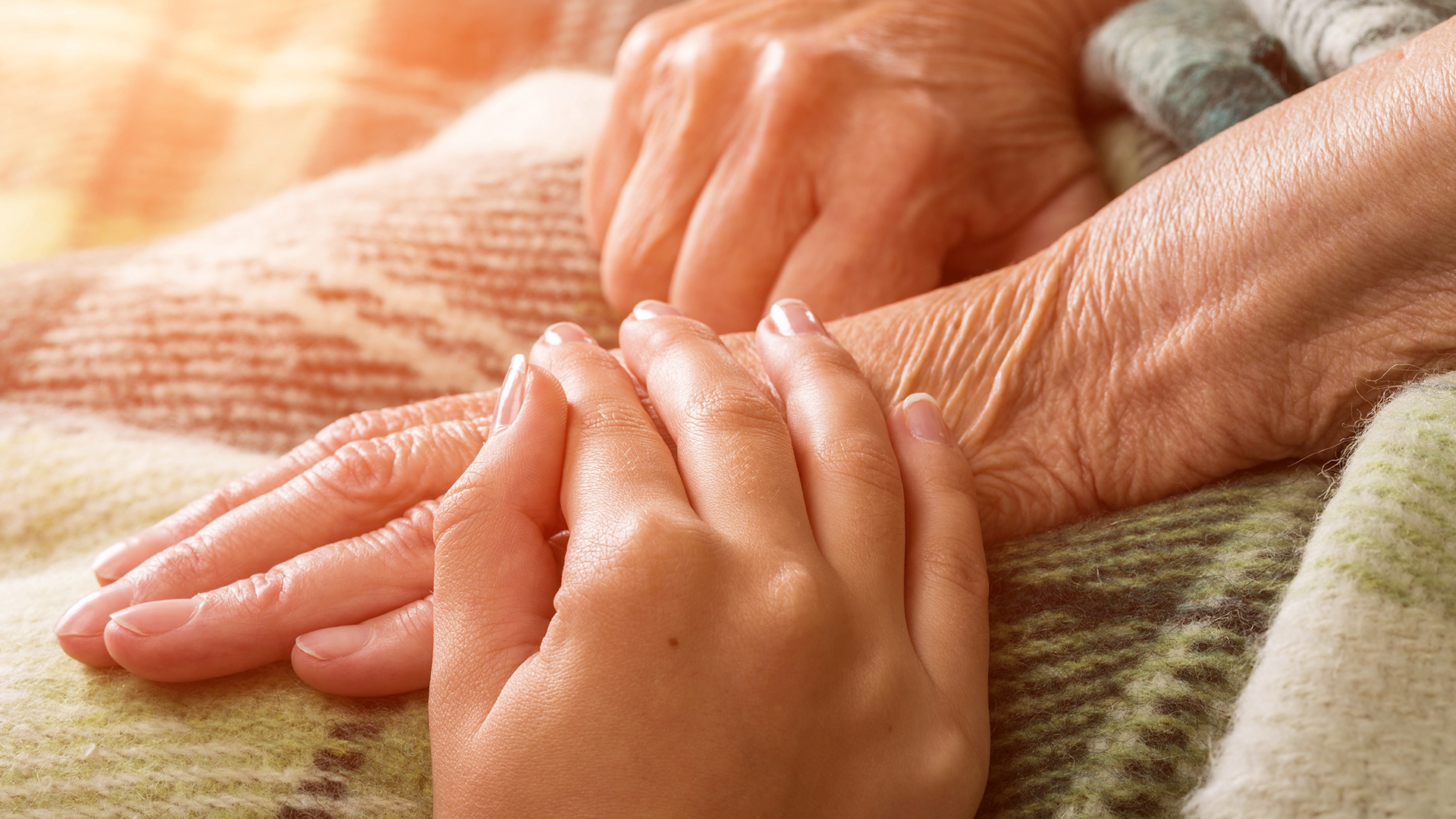 Person hält die Hand eines Patienten