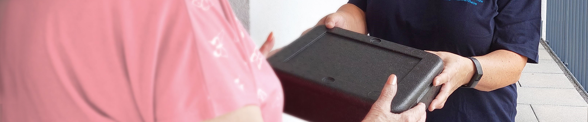 Essen auf Rädern - Box wird überreicht